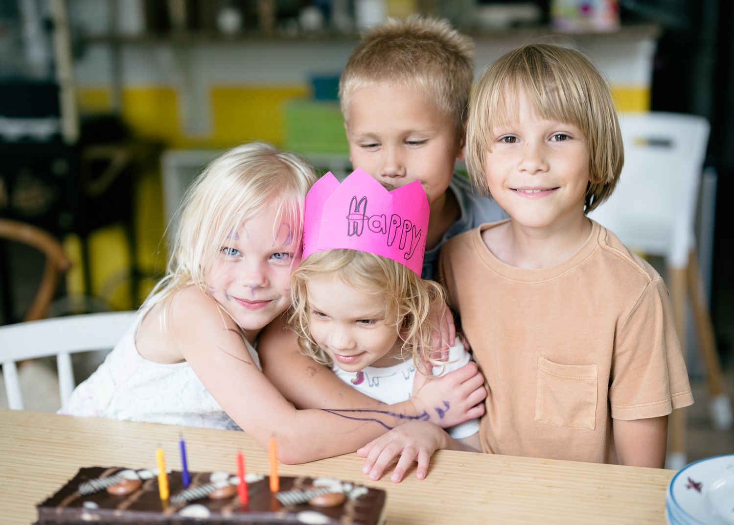 Four children gathered around a birthday cake during a family celebration