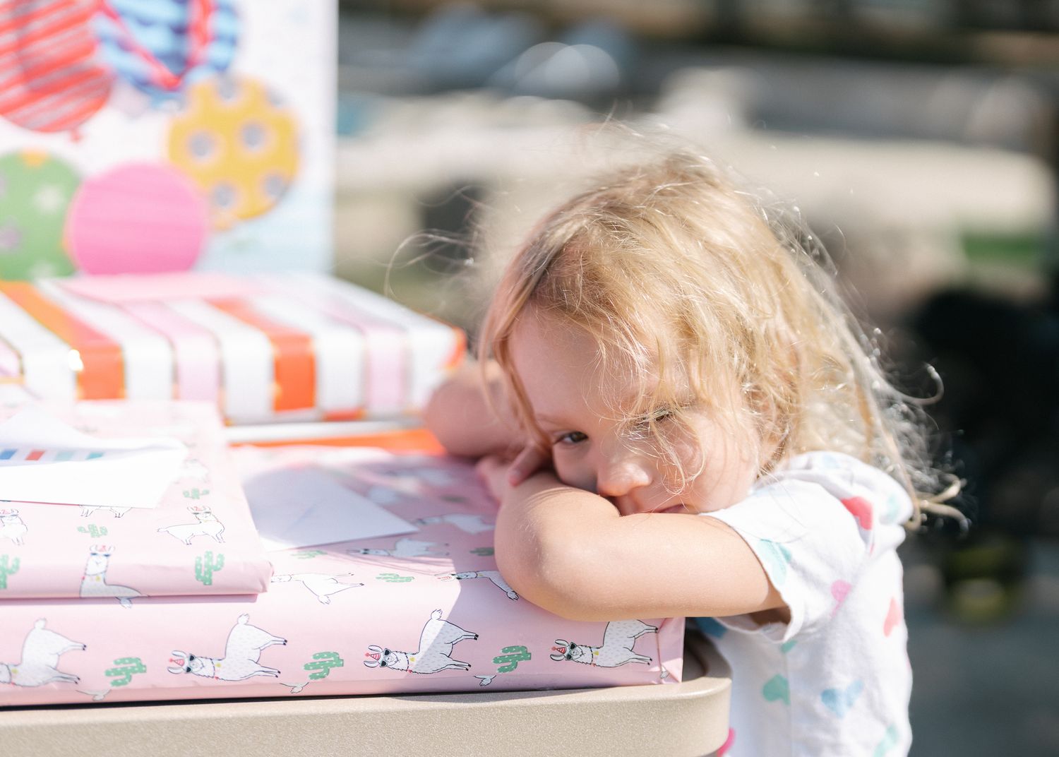 Young girl resting her head on her arms during an outdoor family gathering