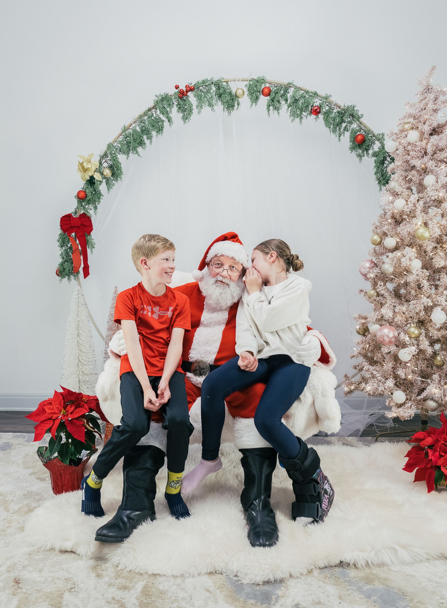 Children sharing a playful moment with Santa during a Christmas photo session in Austin, Texas.