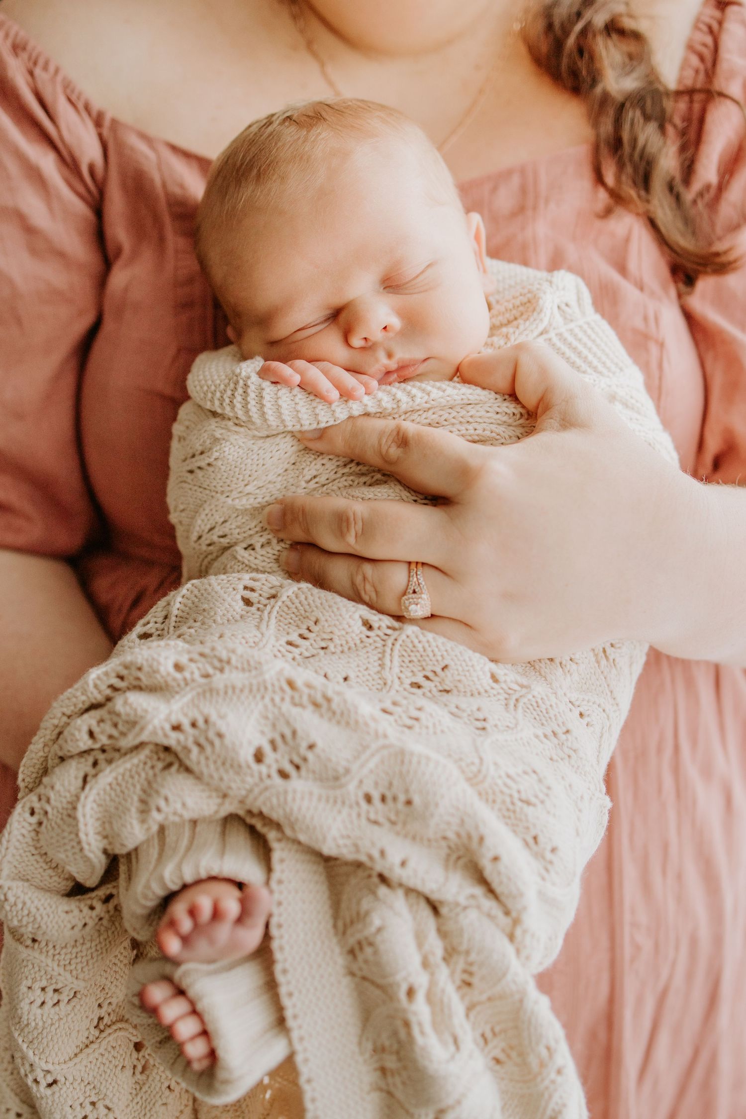 Newborn baby peacefully asleep in mother’s arms — natural in-home newborn photography in Adelaide.