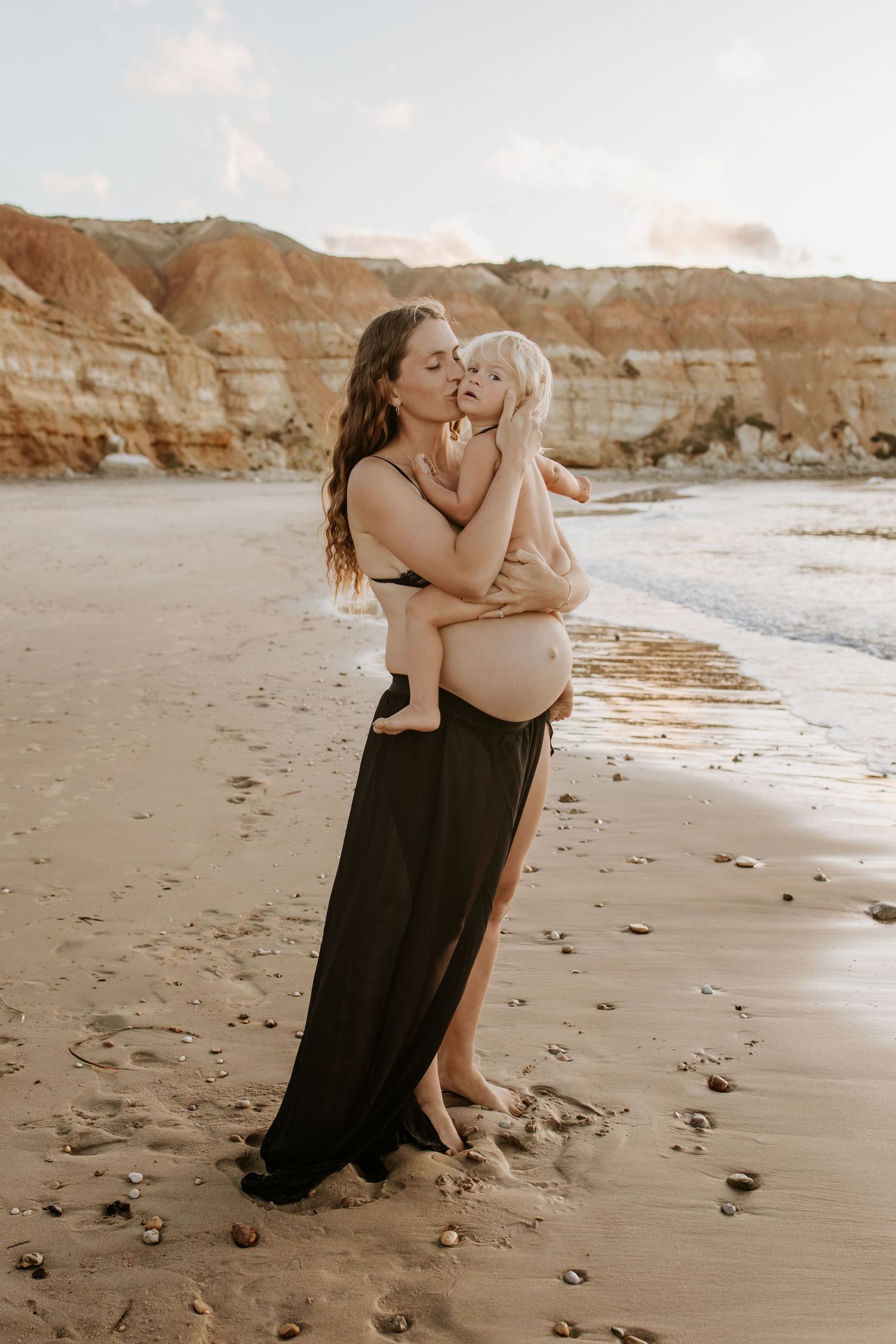 Pregnant mum kissing eldest child — maternity photography by Adelaide maternity and family photographer.