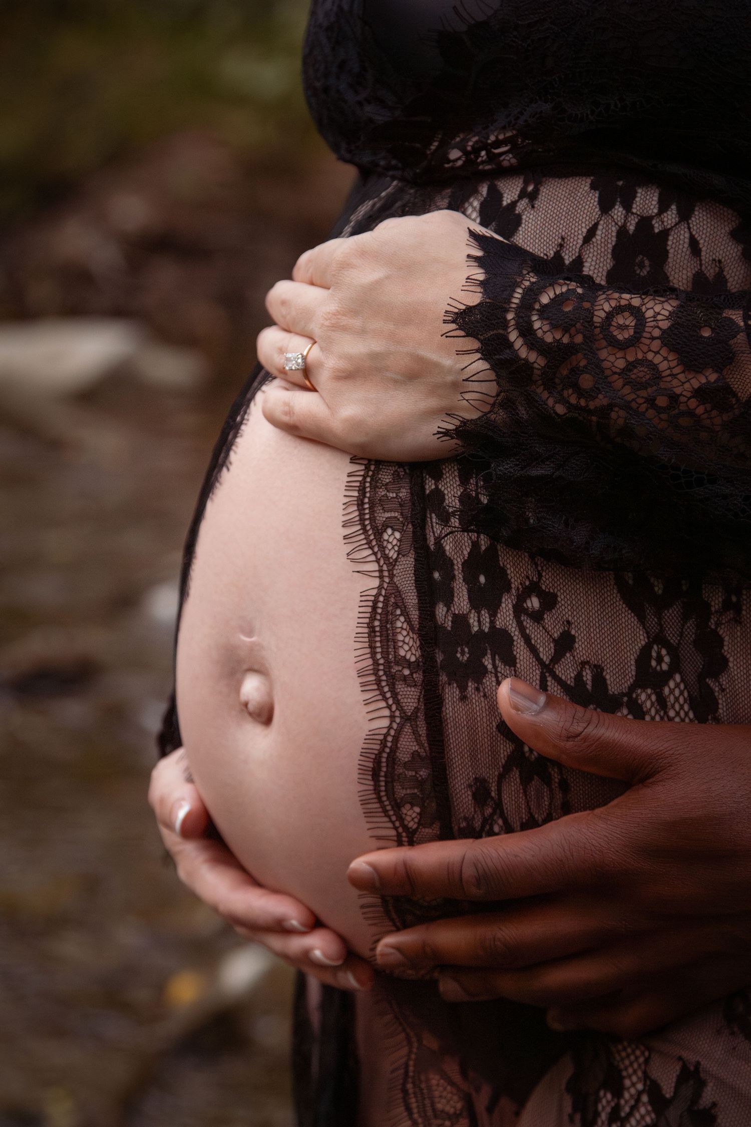 Closeup of baby bump open front lace dress