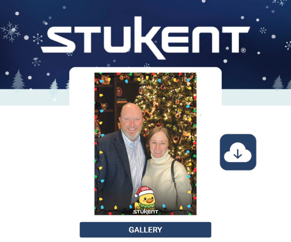 Couple posing together in front of a decorated Christmas tree at a Stukent holiday event.