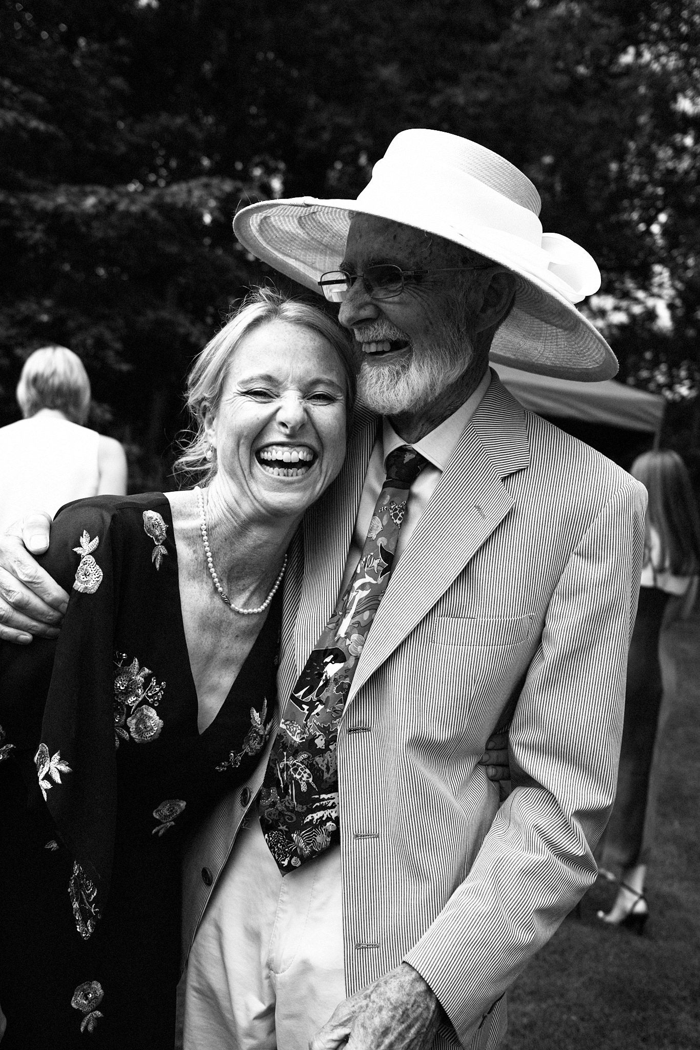 Wedding photo taken at reception. MOB and her father laughing. Monochrome.