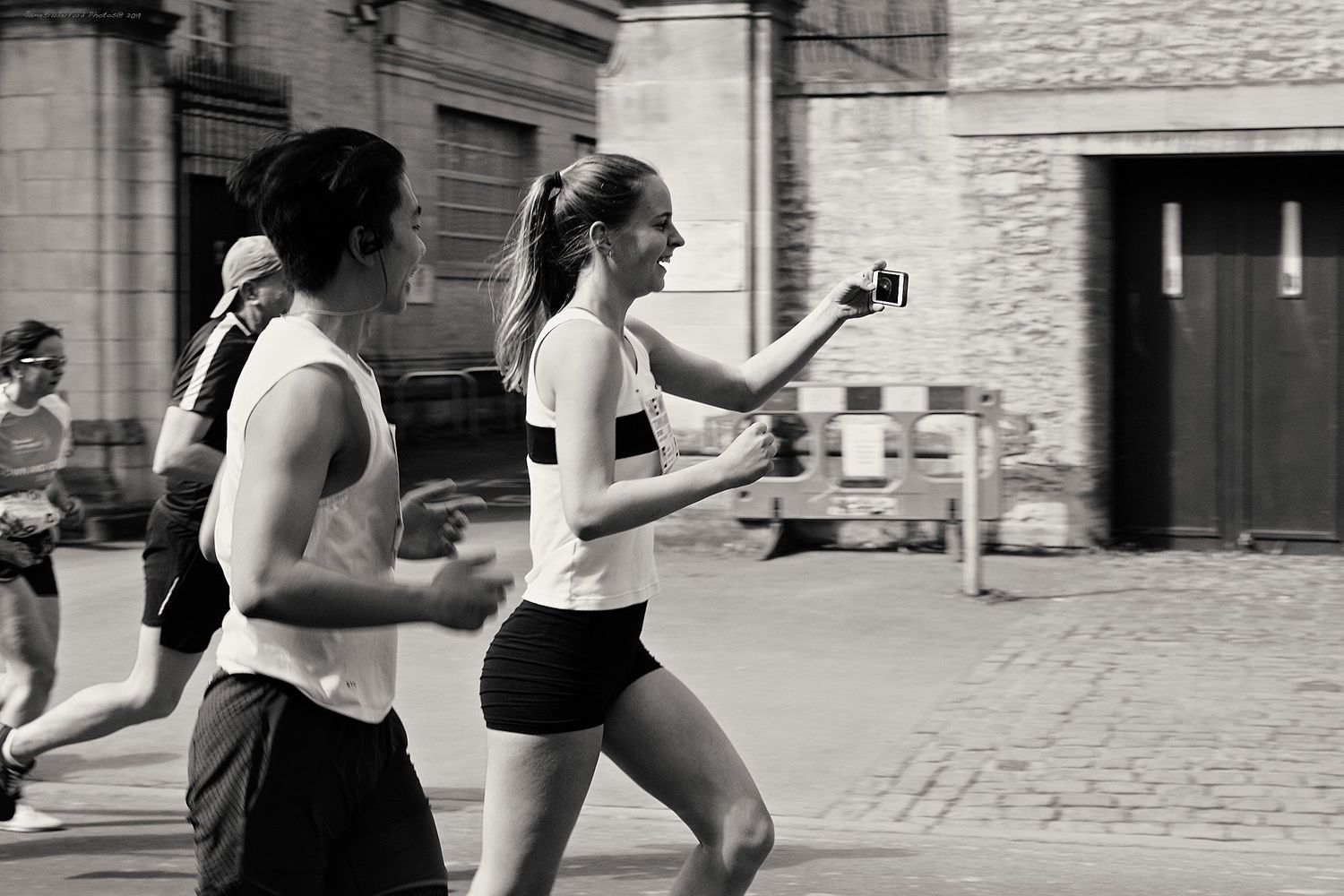 A black and white sequence of athletic movement training exercises being performed against a stone wall background.