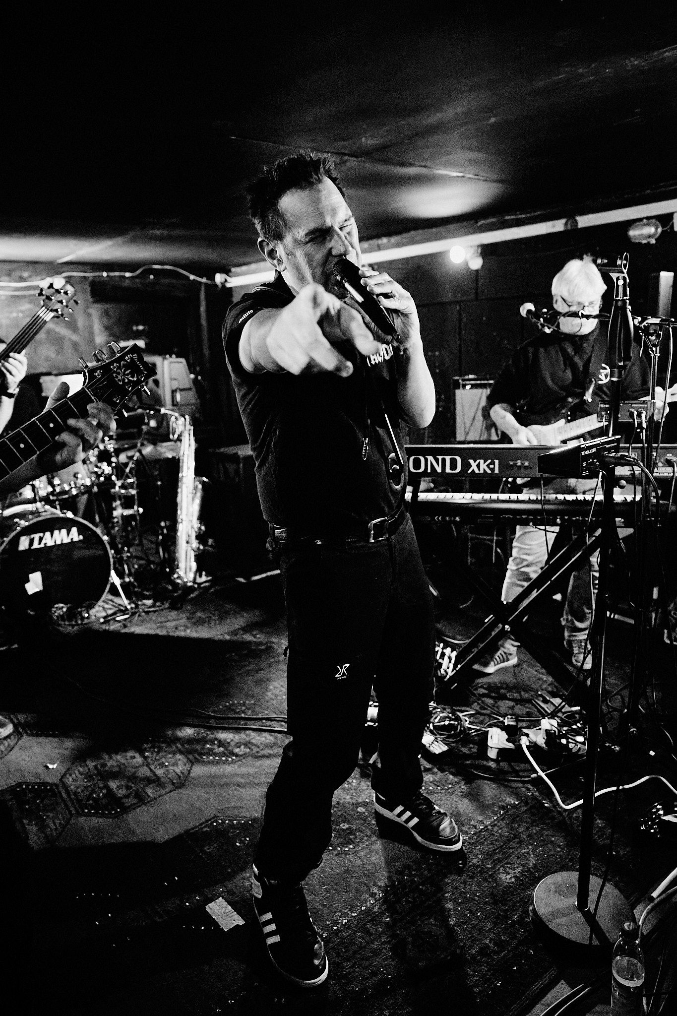 music band playing rock & roll lead singer pointing to photographer. Monochrome