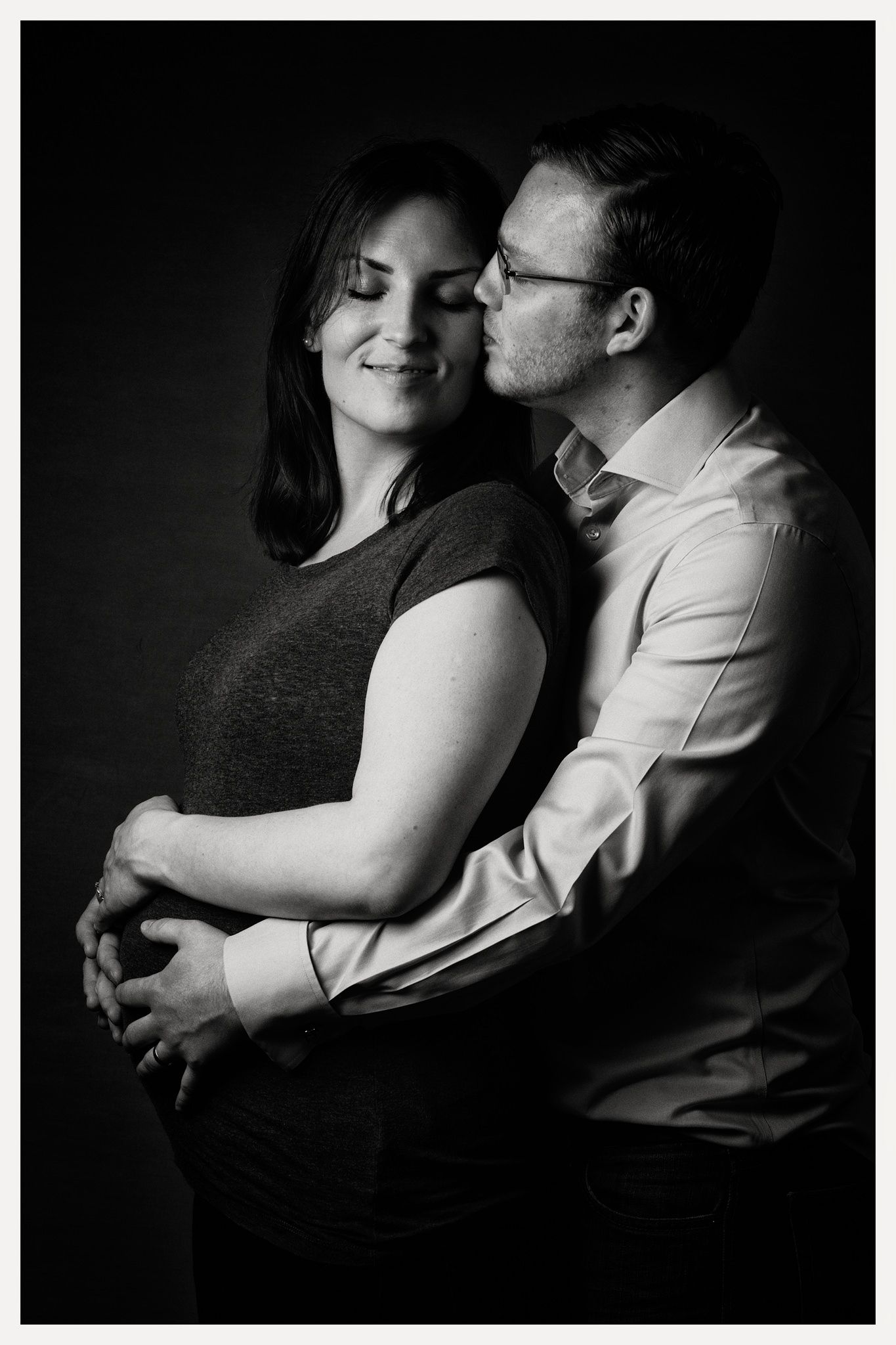 portrait of couple. woman pregnant. couple in each others arms. monochrome