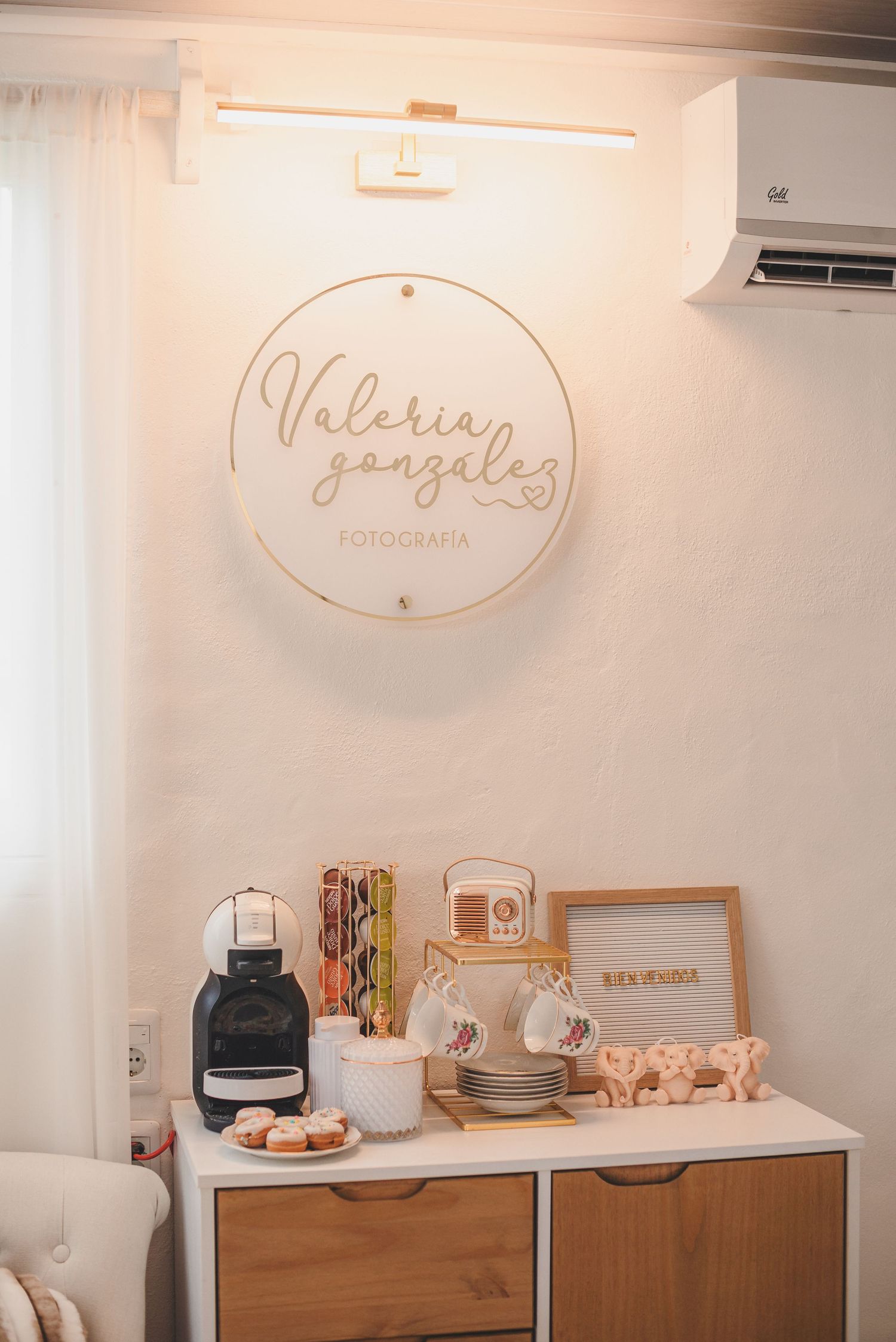 Modern coffee station with wooden cabinet and circular logo sign in photography studio.