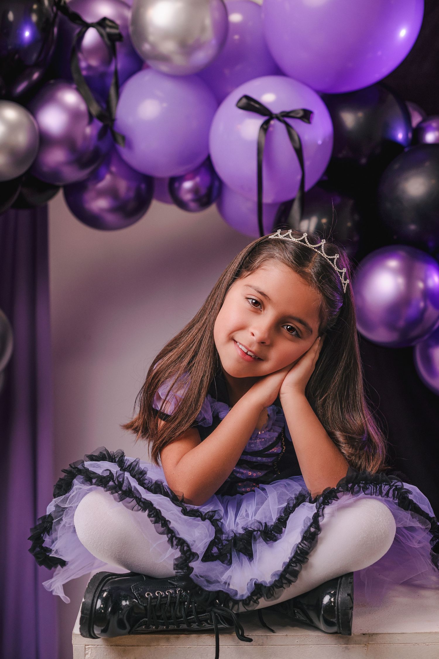 Elegant purple balloon arch creates dreamy backdrop for photo session.