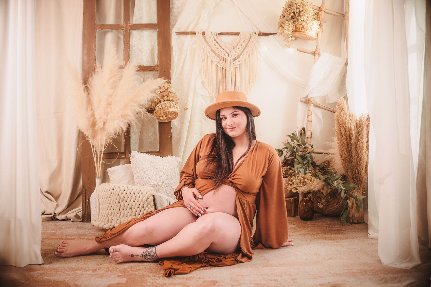 Boho-style maternity session with macrame decorations and natural lighting.