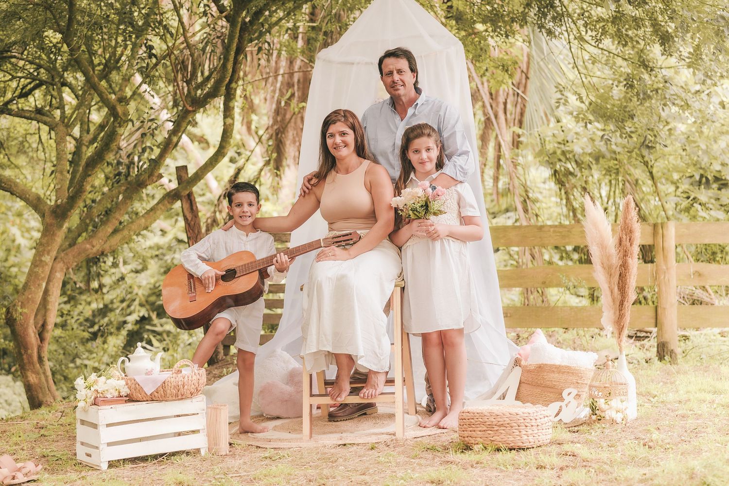 A rustic outdoor family portrait with guitar and floral decor in a garden setting under natural light.