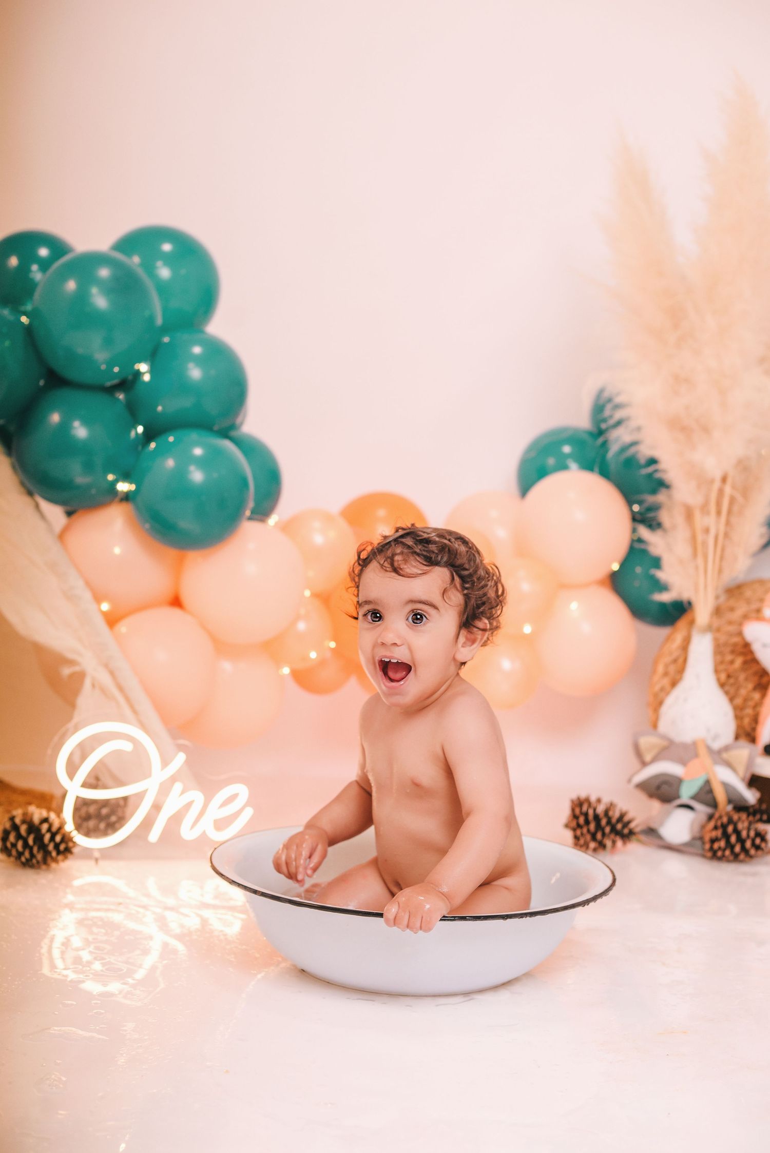 Teal and peach birthday setup with pinecones and natural elements as decorative accents.