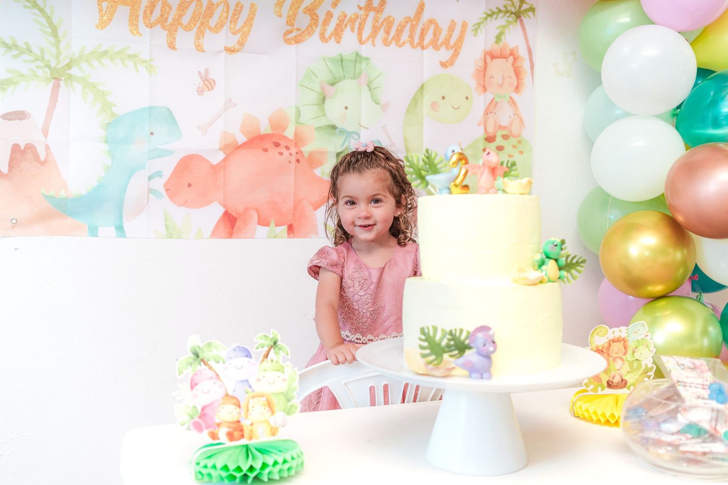 Colorful birthday party decorations with happy birthday text and balloons create a festive celebration atmosphere.