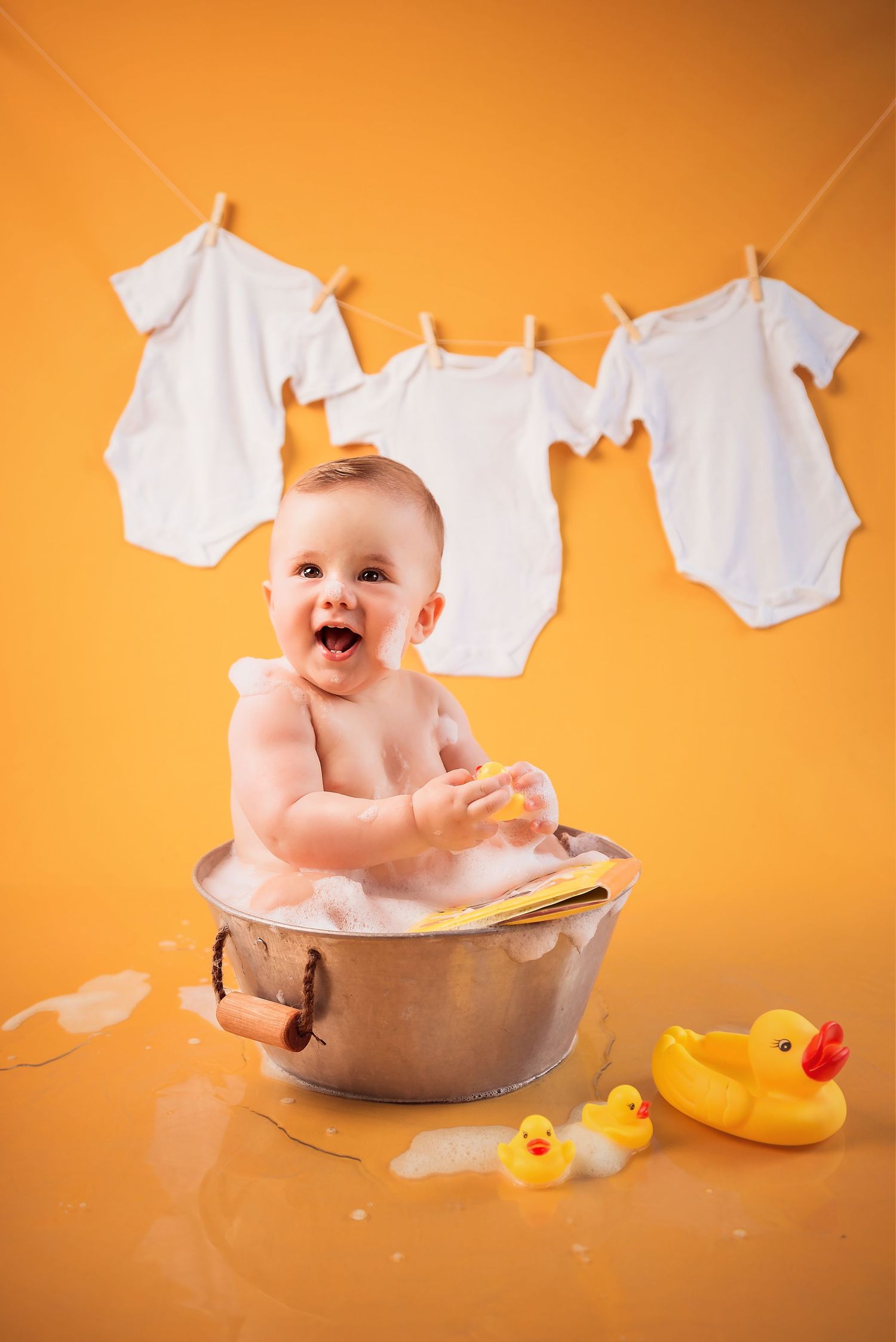 Baby bath time series with rubber ducks and white cloths against orange background showing playful moments in washtub.