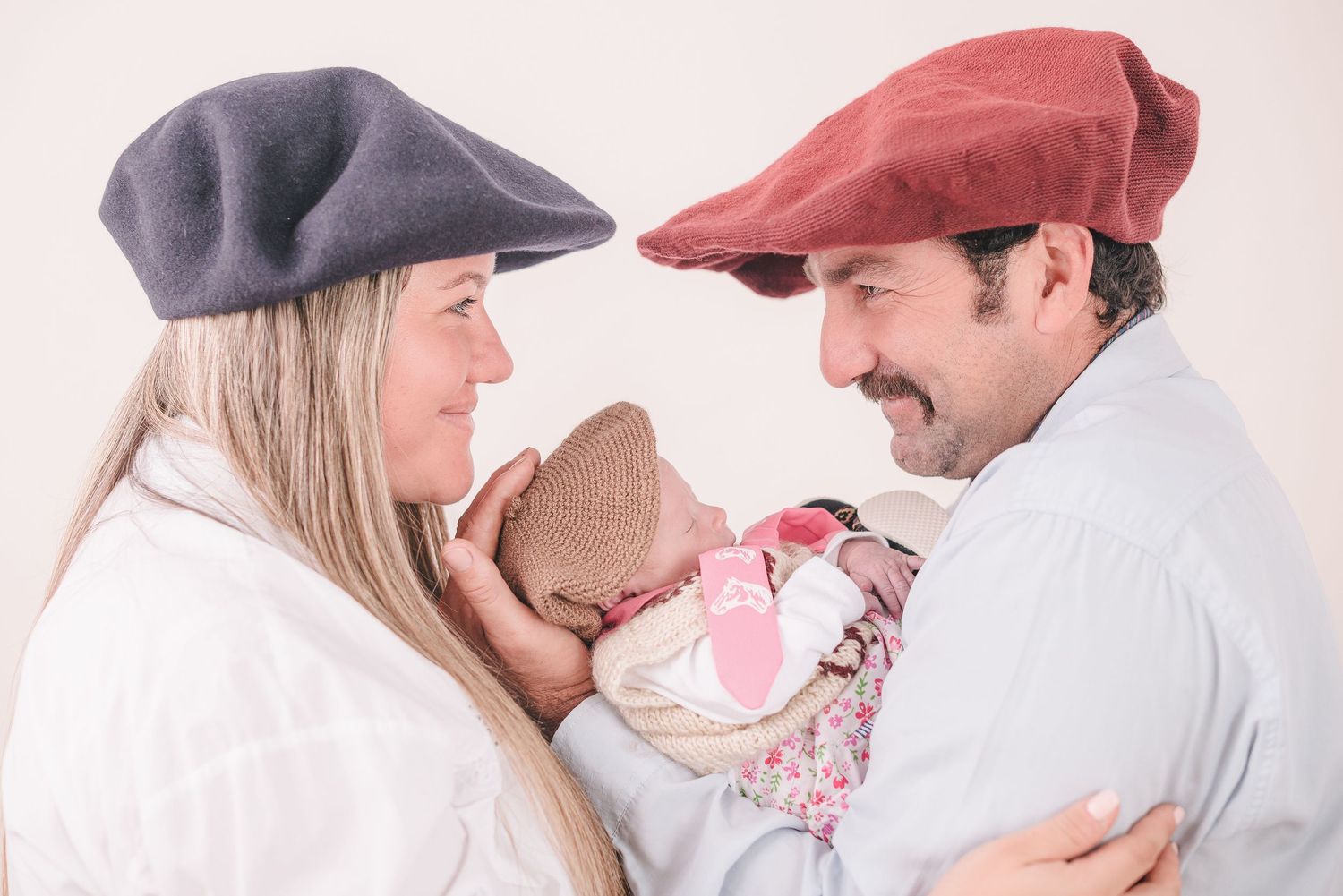 A romantic couple in winter hats shares tender moments in a bright studio setting across four connected photos.