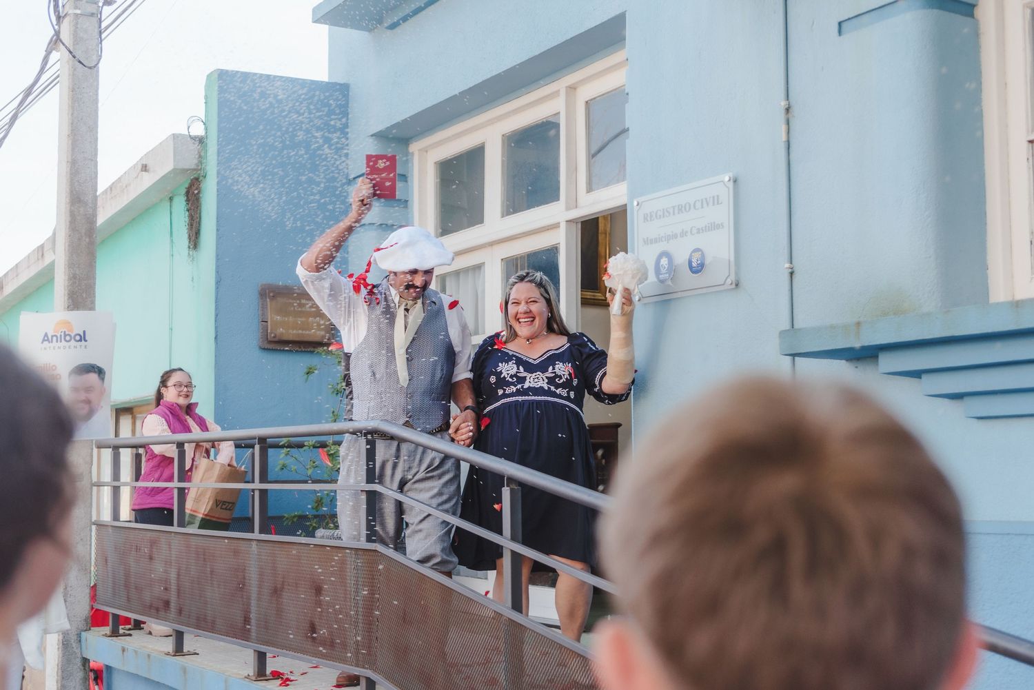 View of people gathered on blue building's exterior staircase.