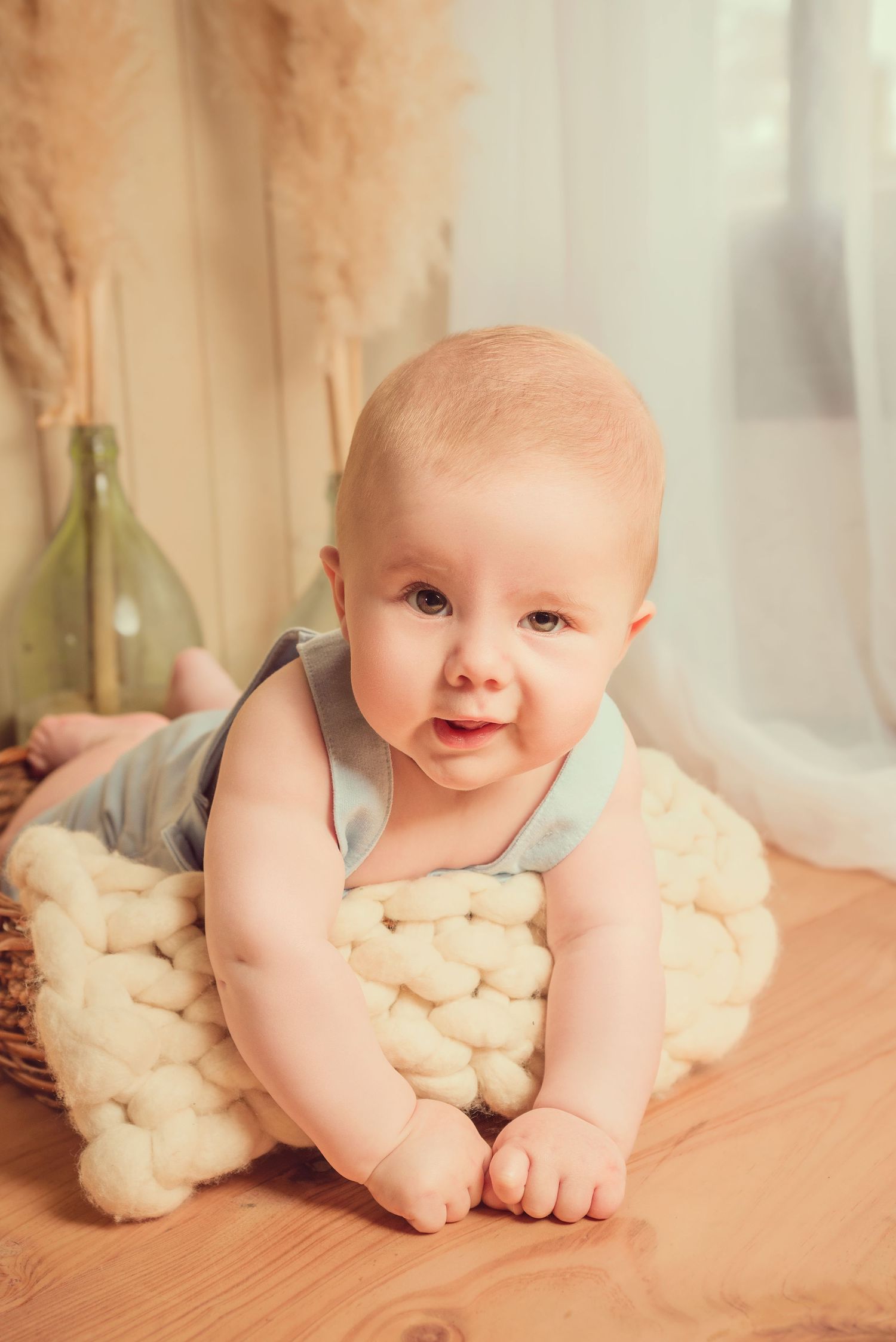A baby lies on a soft cream-colored blanket in a series of sweet poses showing their playful expressions.