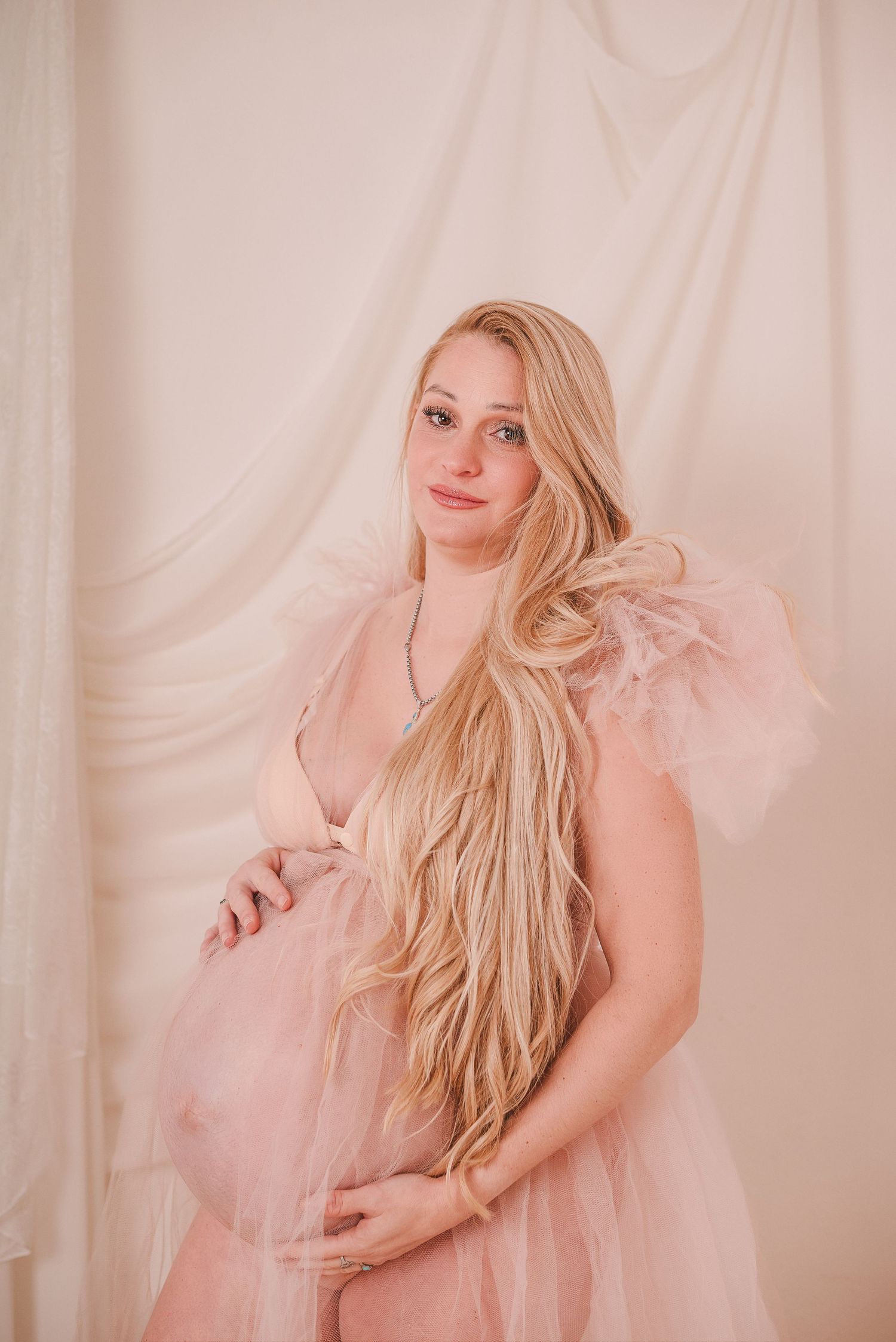 Dreamy portrait session with woman in flowing pink tulle dress.