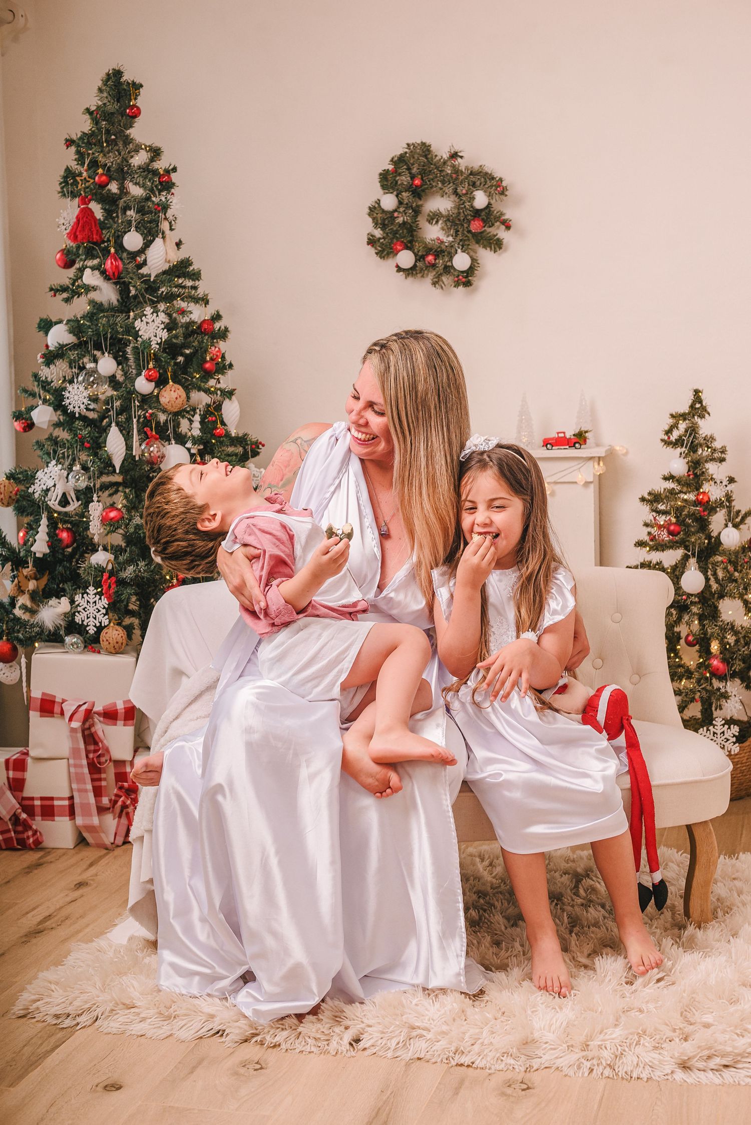 Festive Christmas scene with decorated tree and white armchair.