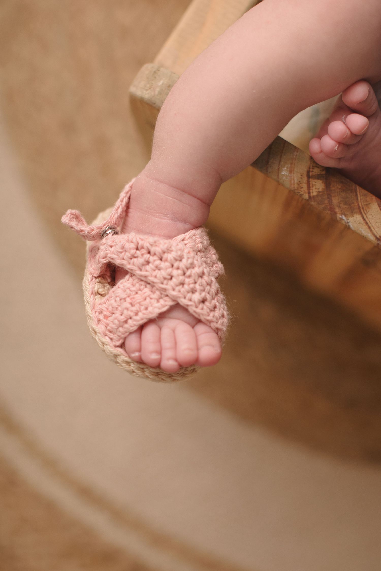 A series of close-up photos showing tiny baby feet wearing delicate pink crocheted sandals.