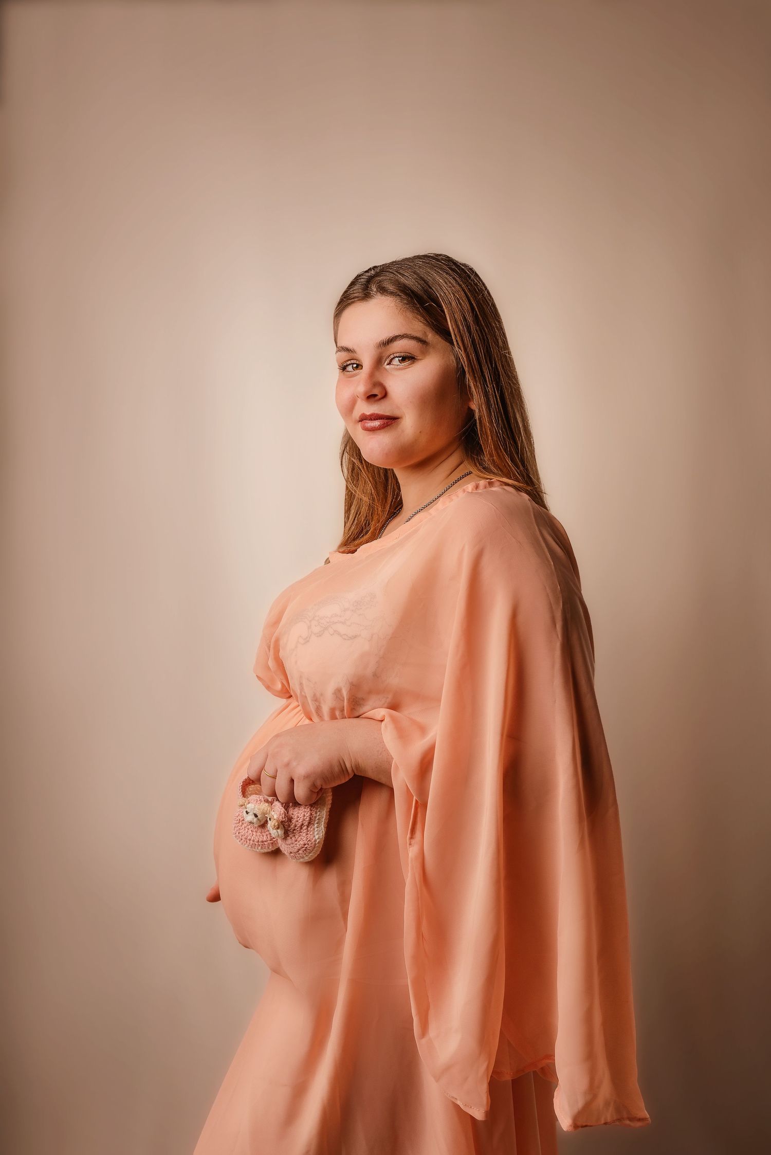 A figure in a flowing peach-colored silk dress poses gracefully against a neutral backdrop in a series of artistic shots.