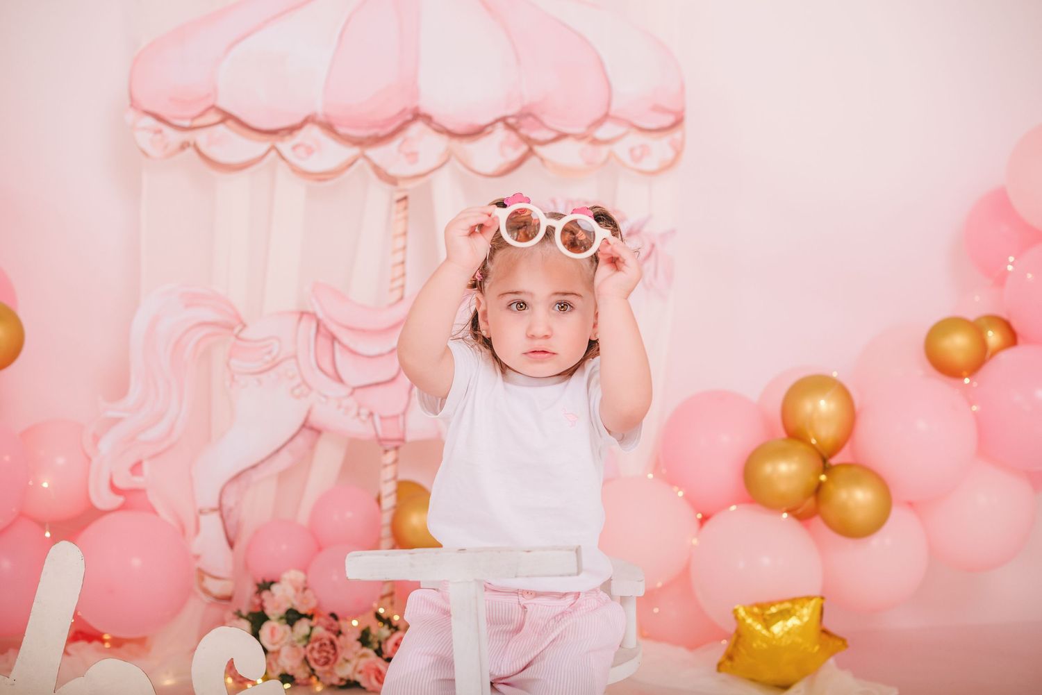 Pink and gold balloon decorations create a whimsical party backdrop.