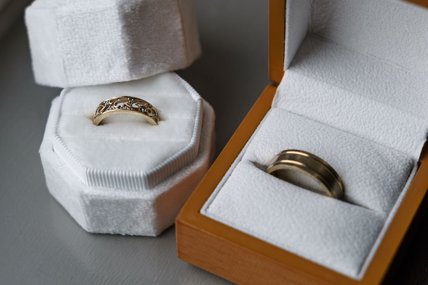 Two gold wedding rings displayed in elegant white velvet jewelry boxes at Wildes Inn, Chesterfield taken by 21 Photography
