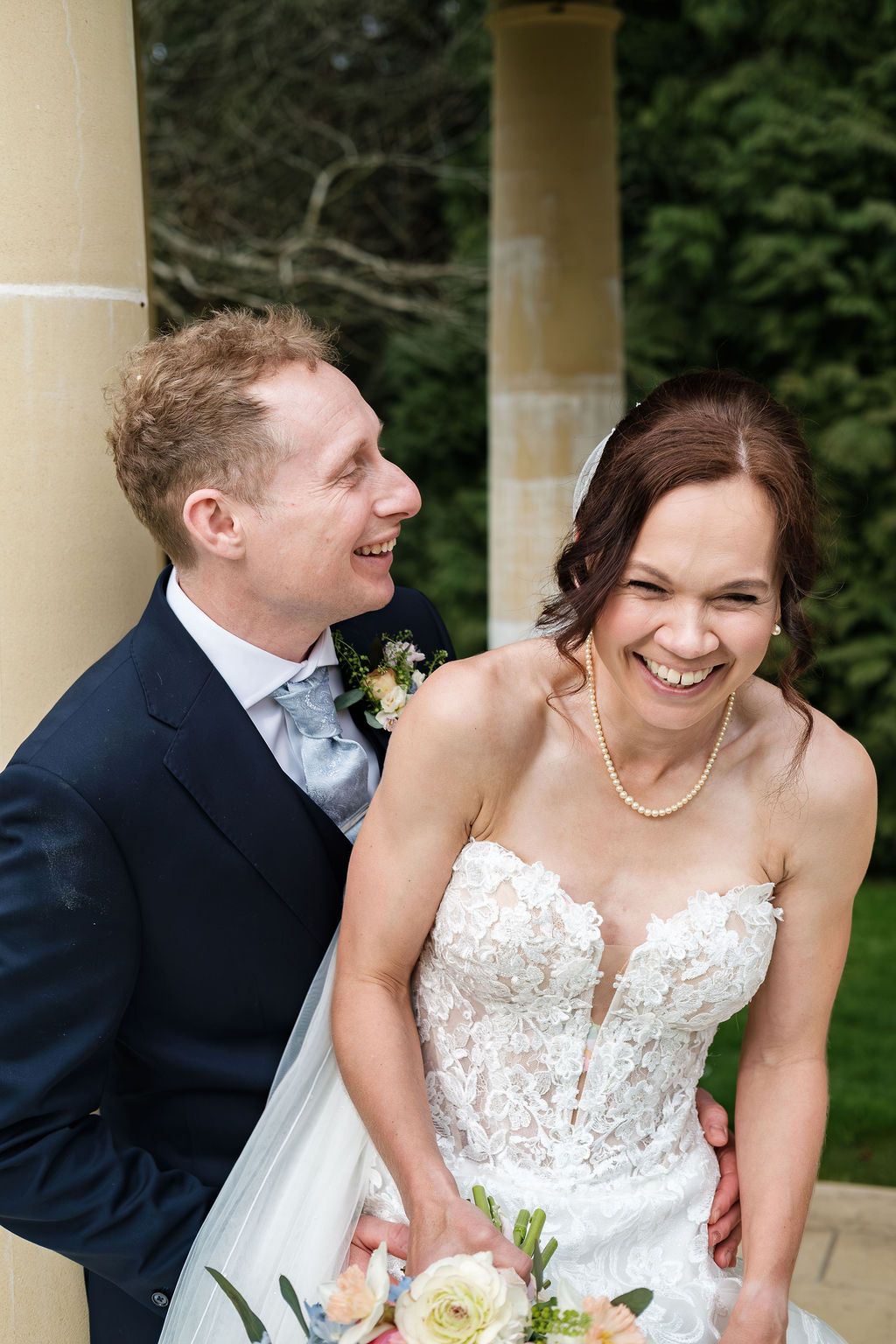 Close laughing portrait of bride and groom outdoors