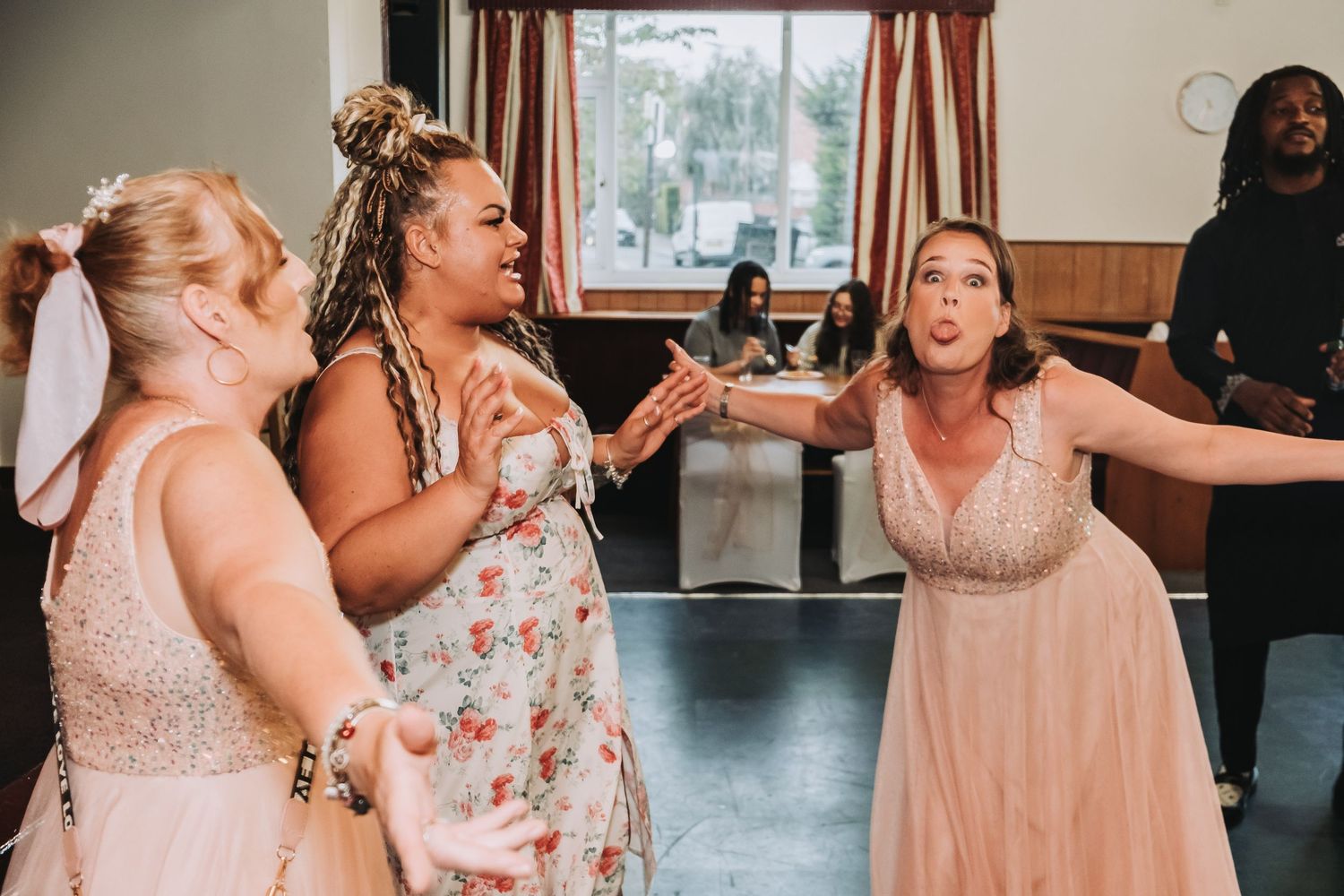 Party guests dance and celebrate together with joyful expressions at a wedding reception.