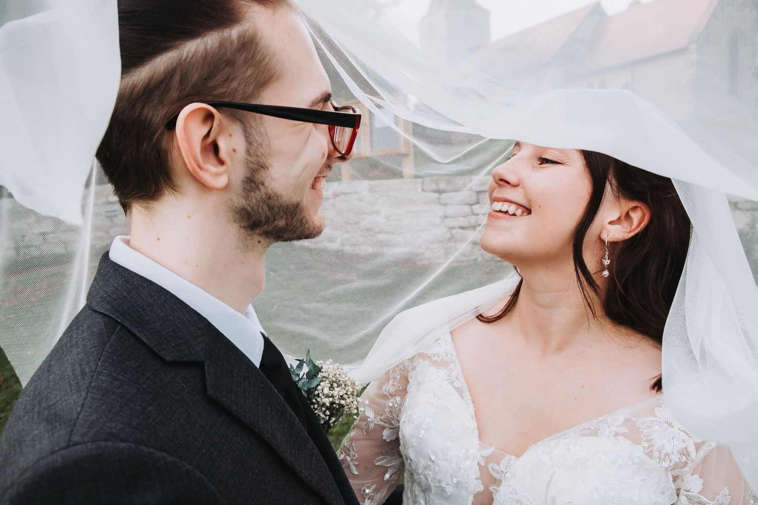 A flowing white wedding veil billows in the breeze during an outdoor portrait session.