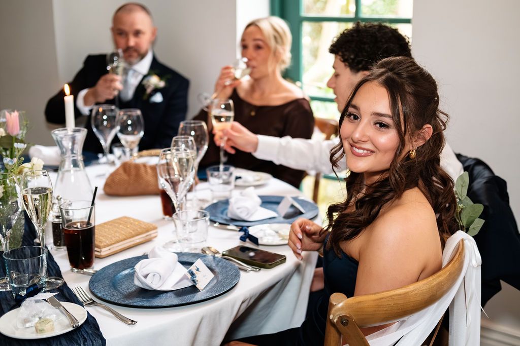 Guests raising a toast at a table set with candles and blue place settings
