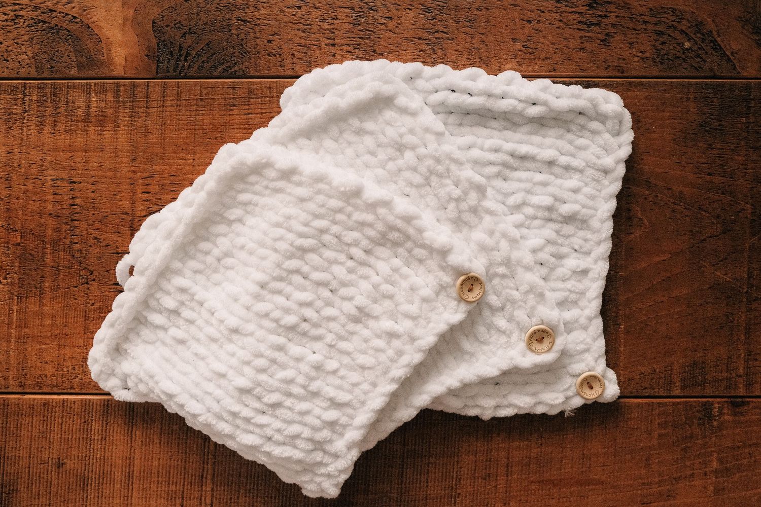 White knitted fabric with detailed stitch pattern on wooden surface shot in Chesterfield by 21 Photography