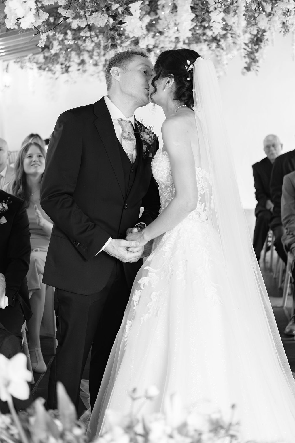 Bride and groom's first kiss at the altar, black and white