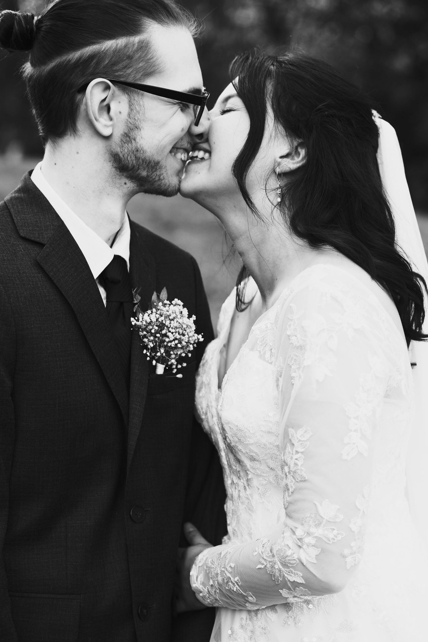 A romantic black and white wedding photo series showing intimate kisses between bride and groom.