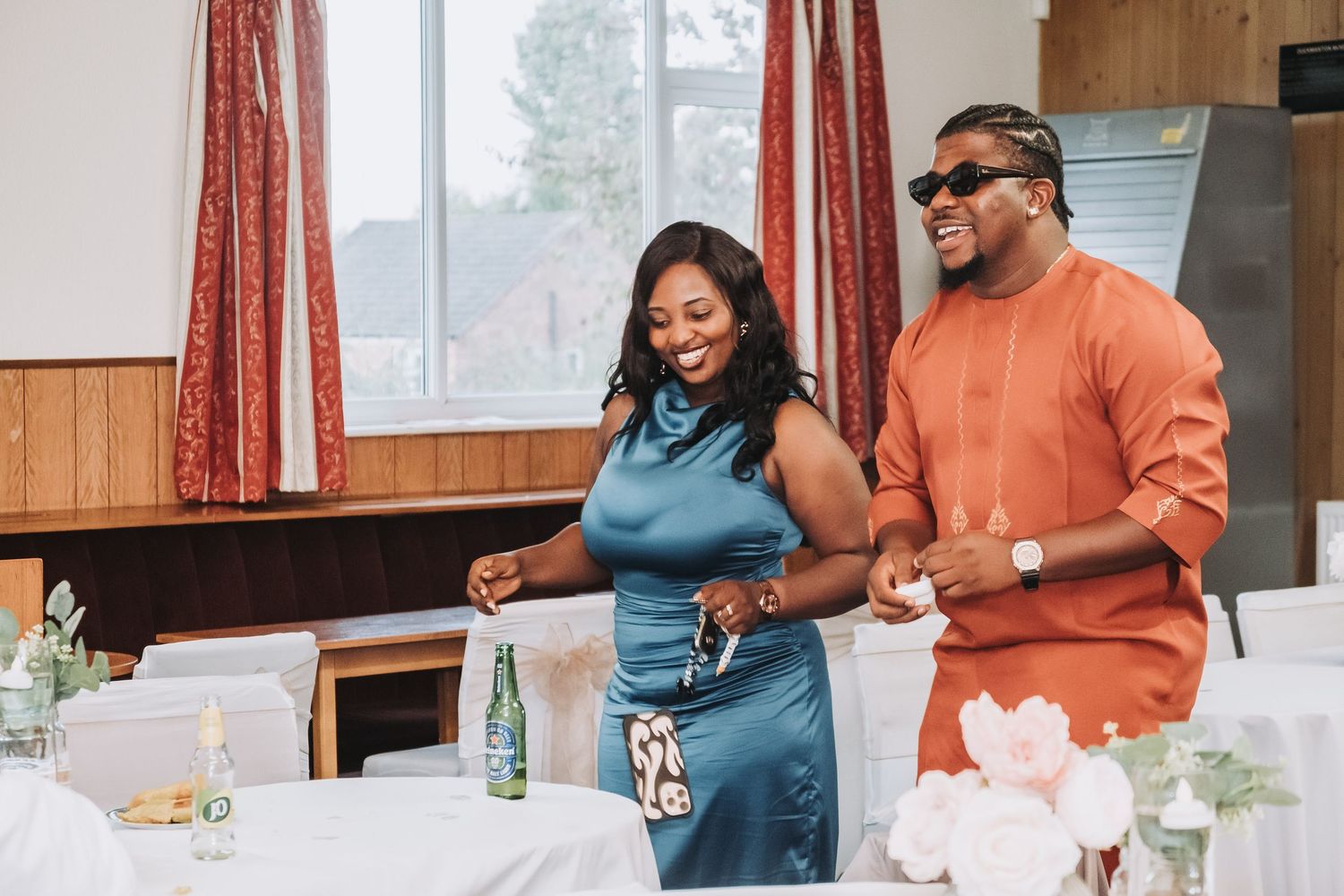 Wedding reception guests socializing at decorated indoor venue.