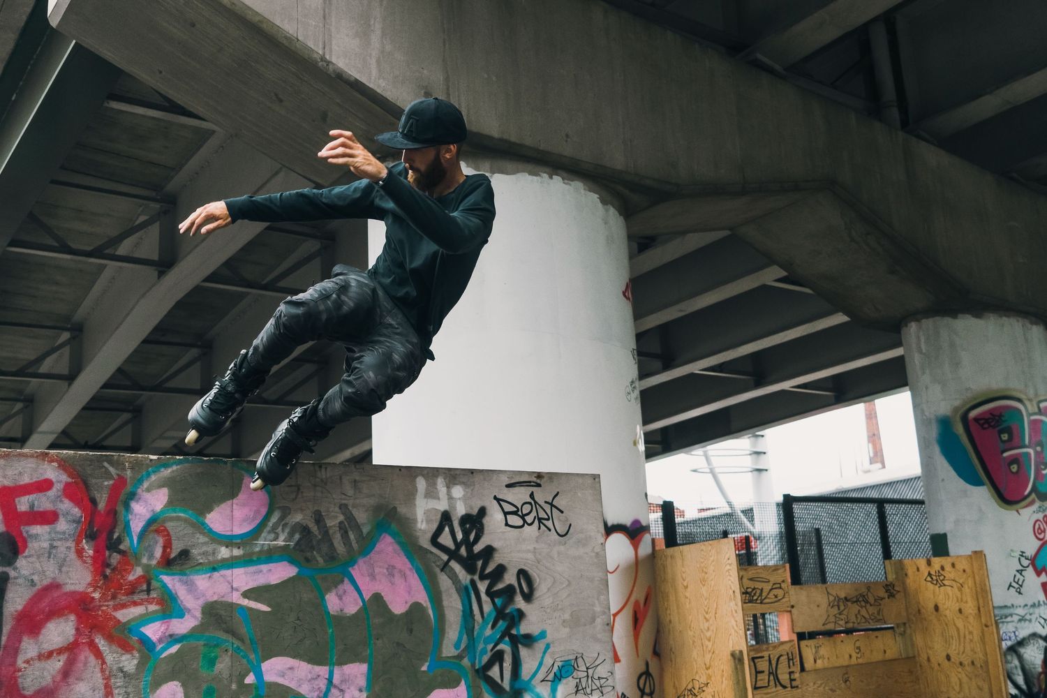 Freestyle BMX rider performs aerial maneuver in concrete skate park with graffiti backdrop shot in Leeds by 21 Photography