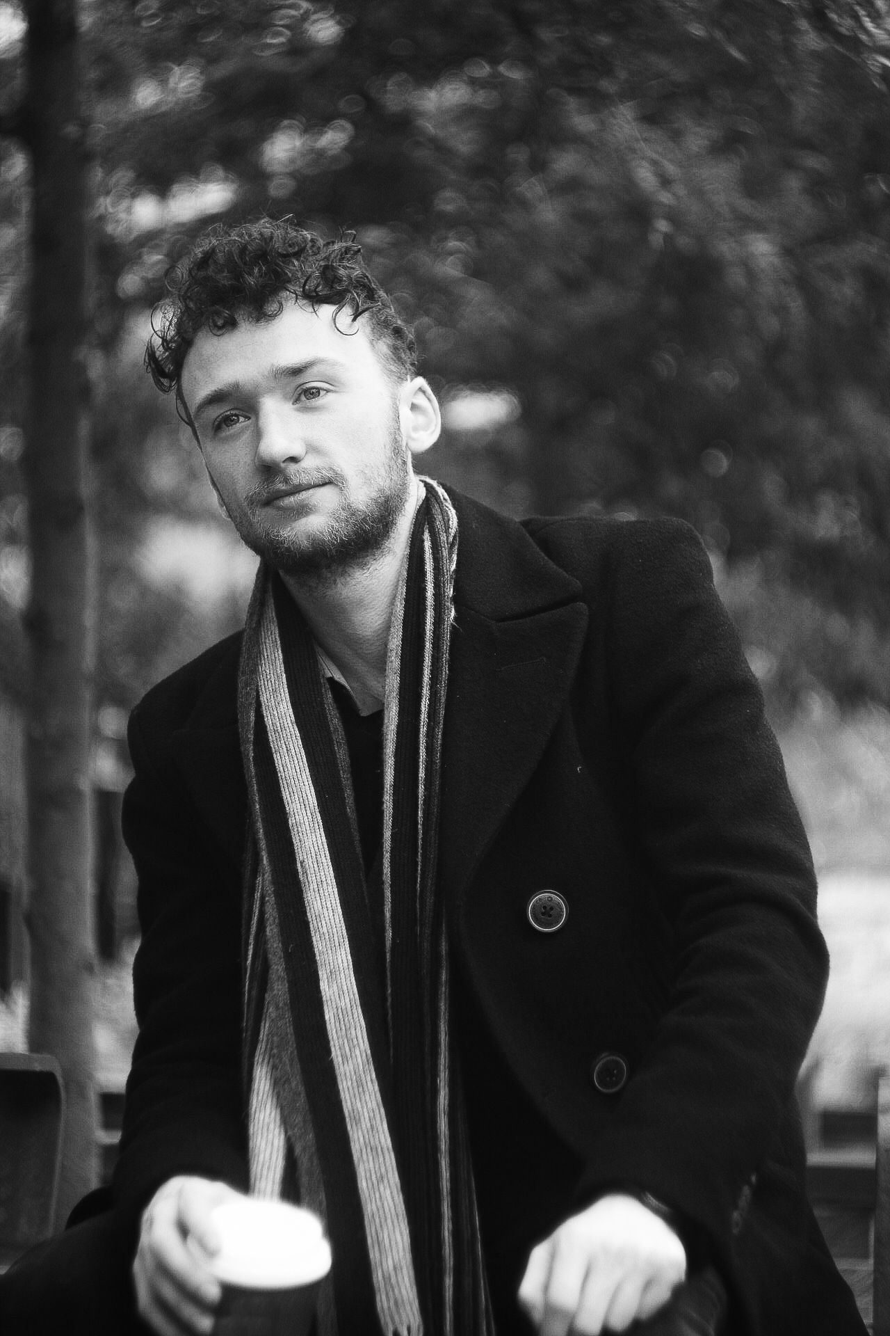 Black and white portrait series featuring someone in winter attire against a blurred background.