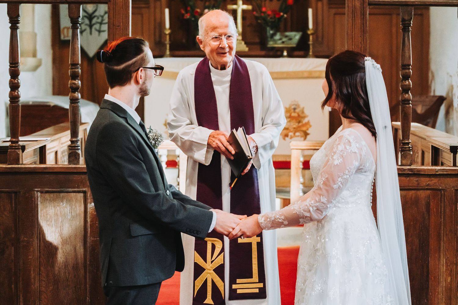 Wedding party members exchange joyful greetings and hugs during an indoor celebration.