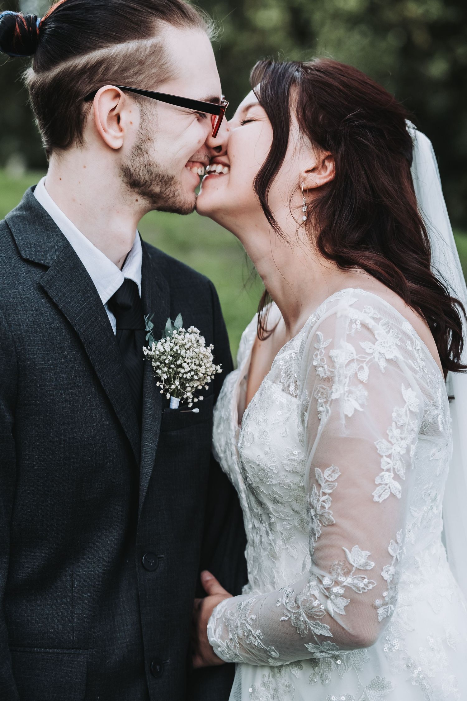 A romantic wedding couple shares tender kisses in a series of intimate outdoor portraits featuring delicate lace details.