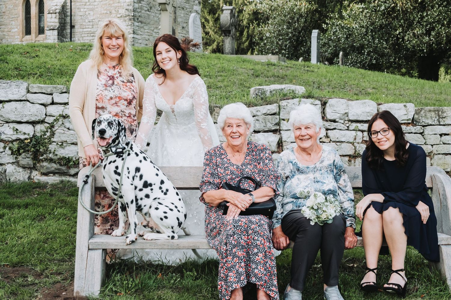 Wedding guests relaxing on stone steps during Tyson and Rebecca’s outdoor celebration in Derbyshire.