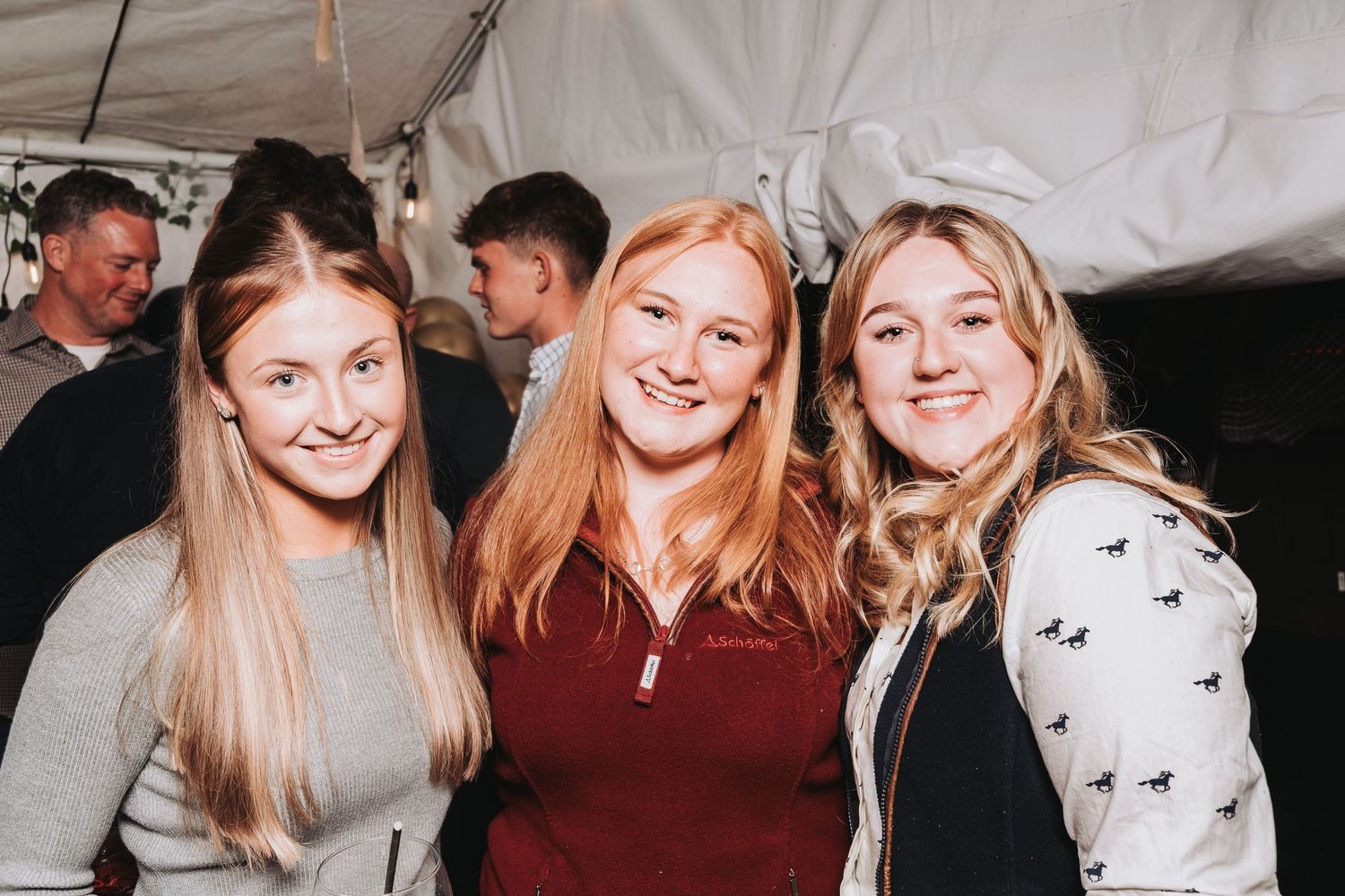 Group of friends celebrating at a casual indoor gathering wearing casual attire.