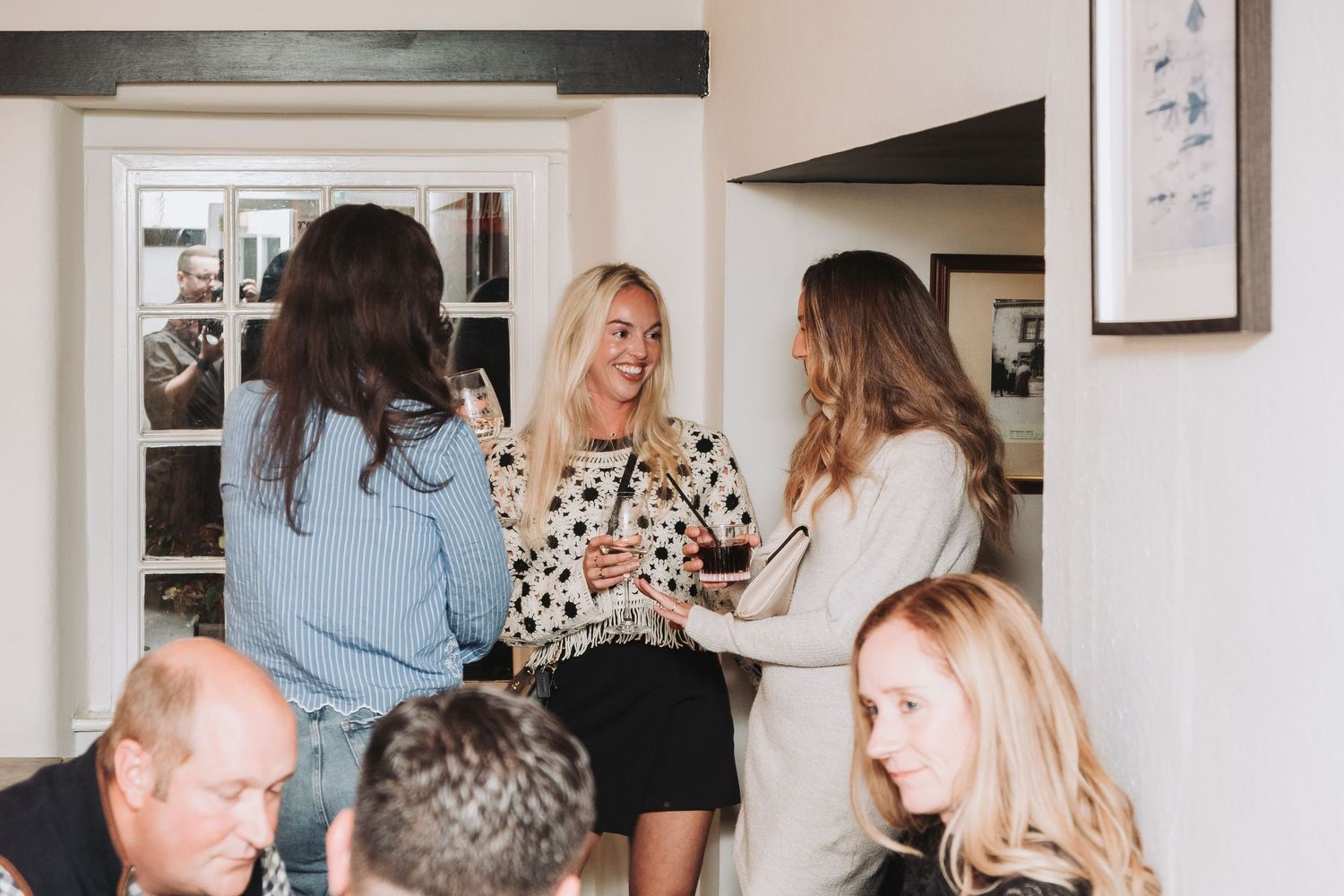 A candid shot of people socializing and mingling at an indoor gathering.