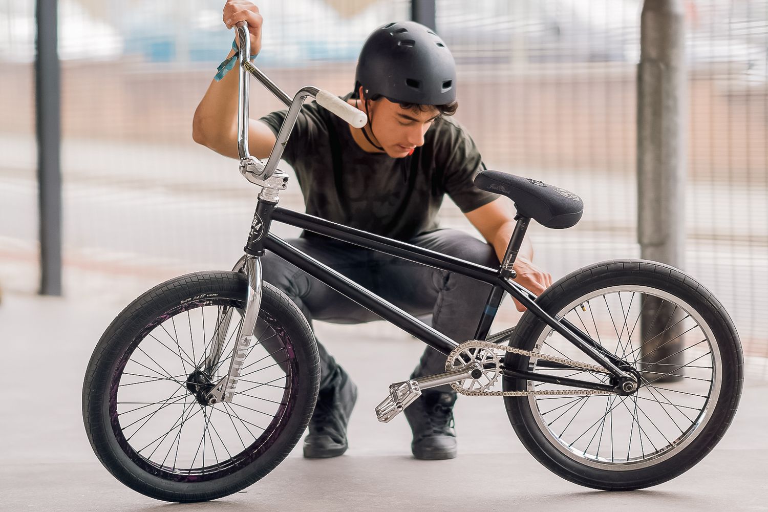 BMX bike rider adjusts handlebars on black bicycle in urban setting shot in Leeds by 21 Photography