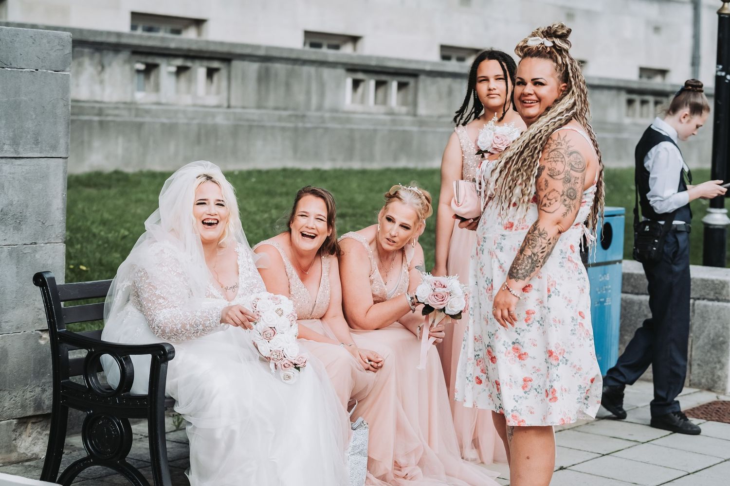 A collage of wedding party photos showing bridesmaids in blush pink dresses with the bride in white lace.