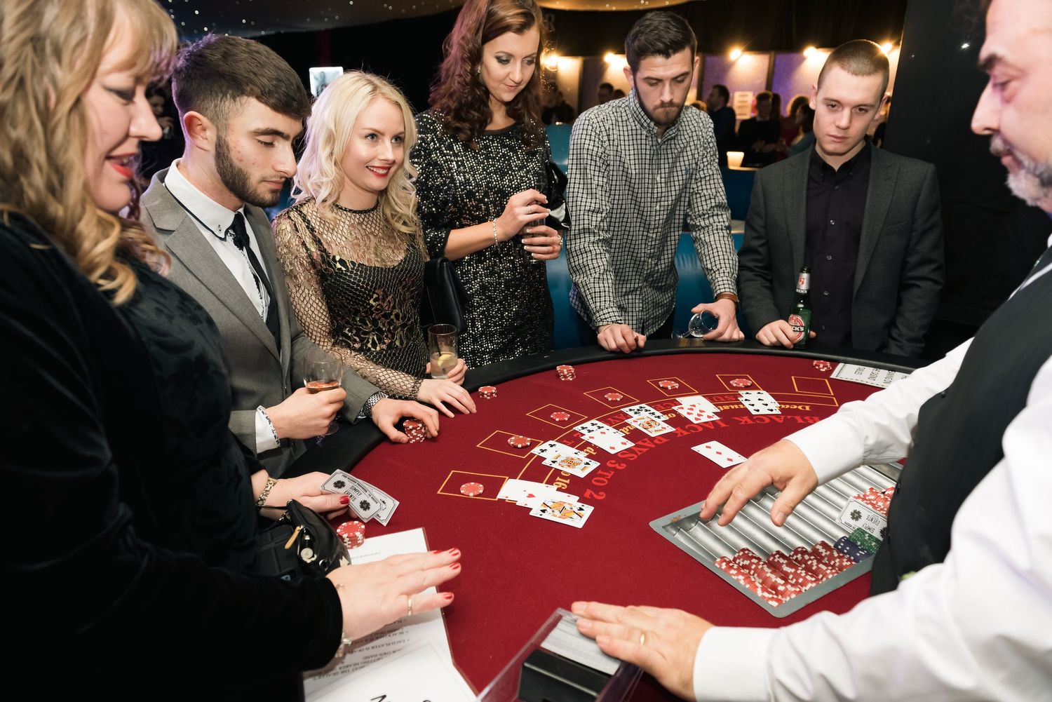 Group of people gathered around a casino table playing cards with a dealer shot in chesterfield by 21 Photography