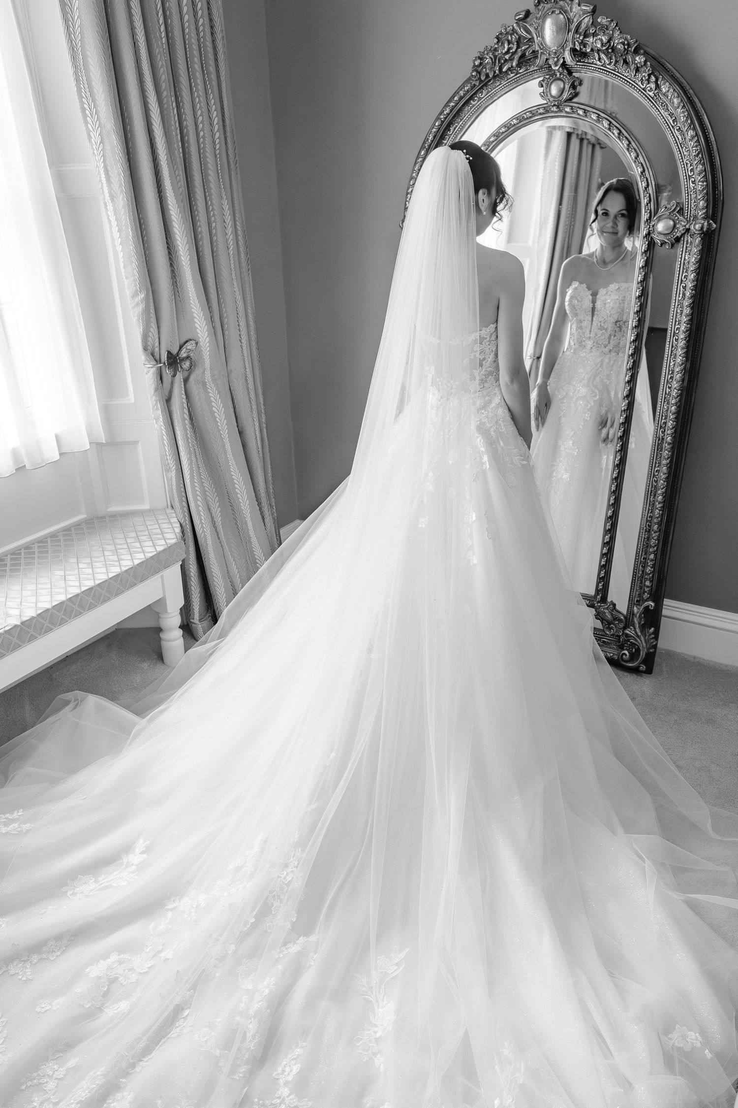 Bride admiring herself in a full length mirror at Dunston Hall Estate