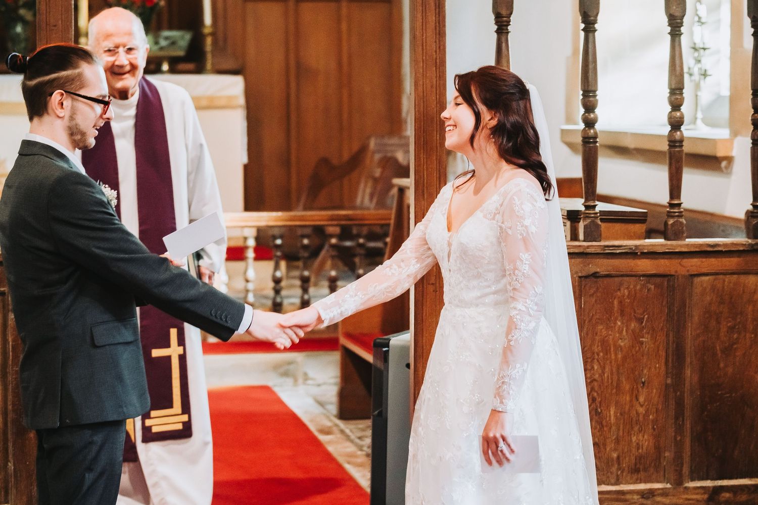 A couple shares their first dance during a wedding ceremony in a church with wooden decor.