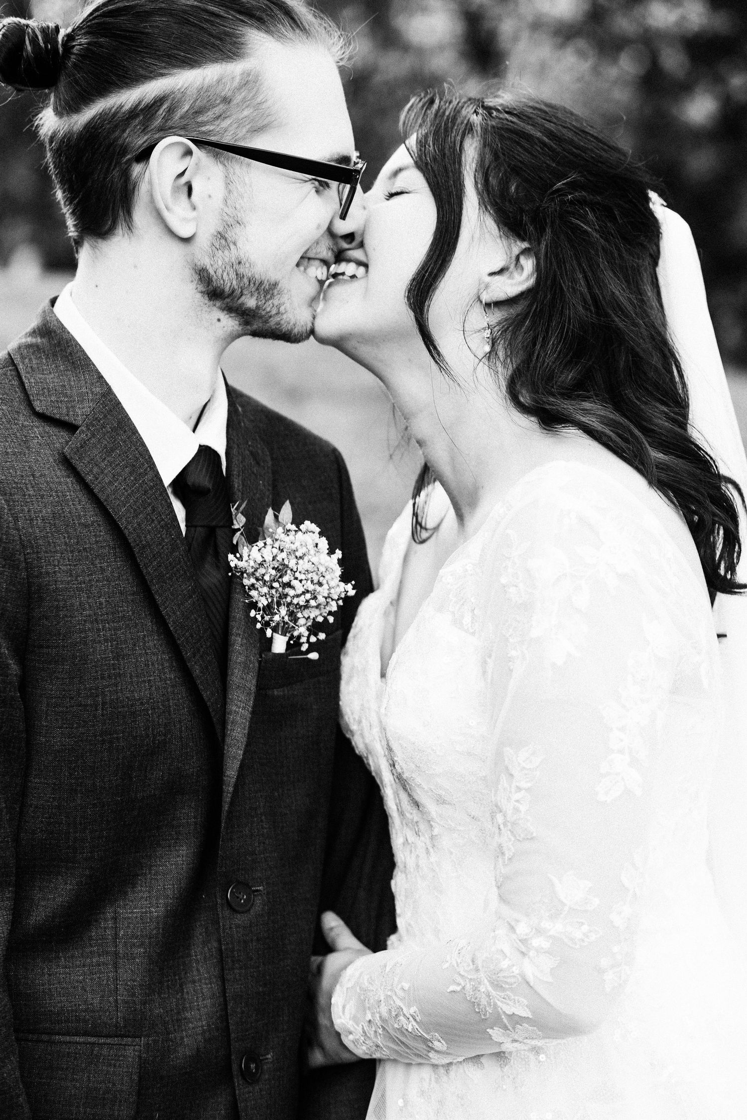 A romantic black and white wedding photo series showing tender moments between newlyweds sharing intimate kisses.