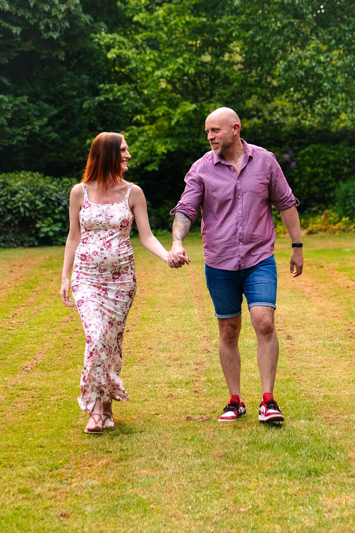 Pair walking together in a sunny park setting, wearing coordinated casual summer outfits.