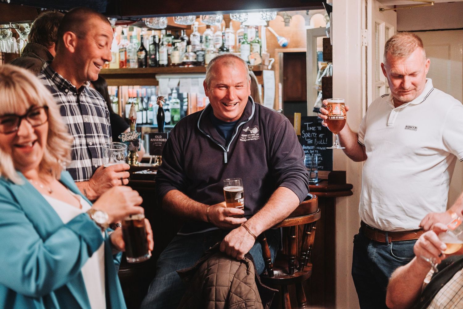 A social gathering at a bar showing people enjoying drinks and conversation.